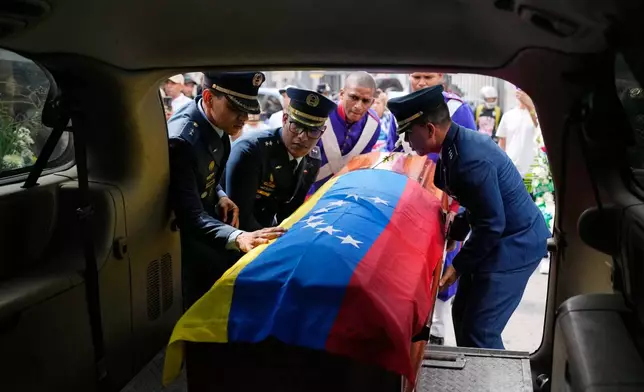 Members of the military place the coffin of Venezuelan soldier Cesar Garcia, killed in a U.S. raid that captured Venezuelan President Nicolas Maduro, into a hearse after his wake in Caracas, Venezuela, Wednesday, Jan. 7, 2026. (AP Photo/Matias Delacroix)