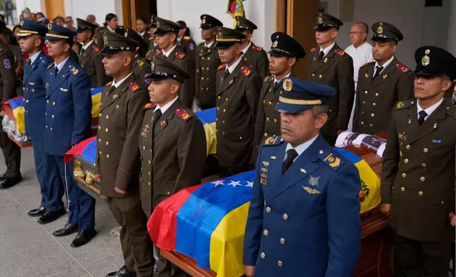 Military personnel stand by the coffins of soldiers killed in the U.S. capture of Venezuelan President Nicolas Maduro and his wife in Caracas, Venezuela, Wednesday, Jan. 7, 2026. (AP Photo/Ariana Cubillos)