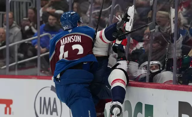 Colorado Avalanche defenseman Josh Manson, left, delivers a hrd check to Washington Capitals defenseman Martin Fehérváry in the second period of an NHL hockey game Monday, Jan. 19, 2026, in Denver. (AP Photo/David Zalubowski)