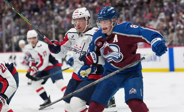 Washington Capitals left wing Anthony Beauvillier, left, and Colorado Avalanche defenseman Cale Makar pursue the puck in the second period of an NHL hockey game, Monday, Jan. 19, 2026, in Denver. (AP Photo/David Zalubowski)