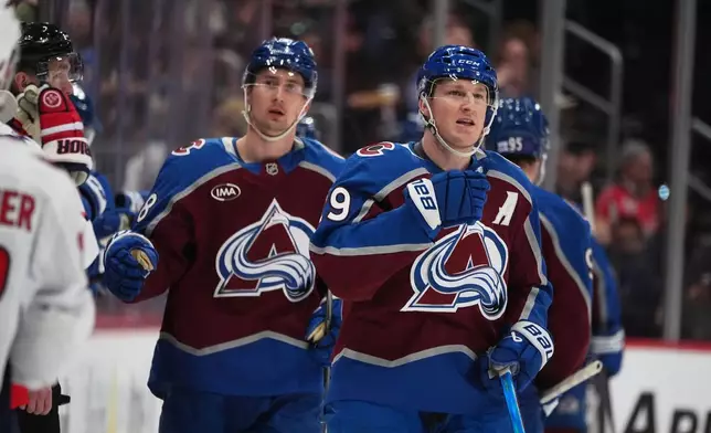 Colorado Avalanche center Nathan MacKinnon, right, reacts after scoring as center Martin Necas, left, follows in the second period of an NHL hockey game against the Washington Capitals, Monday, Jan. 19, 2026, in Denver. (AP Photo/David Zalubowski)