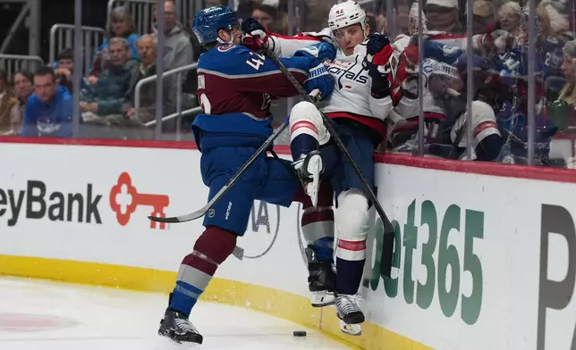 Colorado Avalanche defenseman Josh Manson, left, delivers a hard check to Washington Capitals left wing Anthony Beauvillier in the second period of an NHL hockey game Monday, Jan. 19, 2026, in Denver. (AP Photo/David Zalubowski)