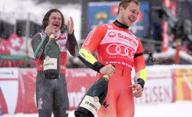 Second placed Brazil's Lucas Pinheiro Braathen, left, celebrates with winner Switzerland's Marco Odermatt, after finishing second in a men's World Cup giant slalom, in Adelboden, Switzerland, Saturday, Jan. 10, 2026. (AP Photo/Giovanni Zenoni)
