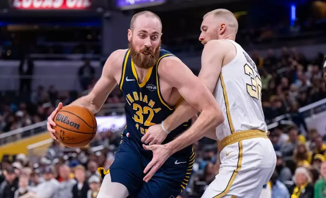 Indiana Pacers center Jay Huff (32) moves toward the basket while being defended by Boston Celtics forward Sam Hauser (30) during the first half of an NBA basketball game in Indianapolis, Monday, Jan. 12, 2026. (AP Photo/Doug McSchooler)