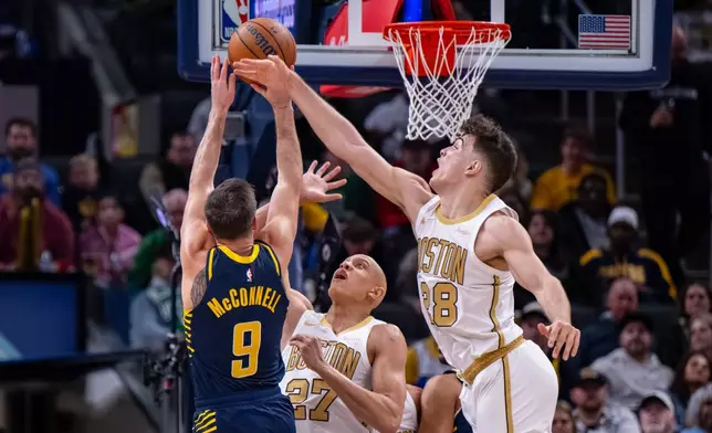 Boston Celtics guards Hugo Gonzalez (28) and Jordan Walsh (27) attempt to block a shot by Indiana Pacers guard T.J. McConnell (9) during the second half of an NBA basketball game in Indianapolis, Monday, Jan. 12, 2026. (AP Photo/Doug McSchooler)