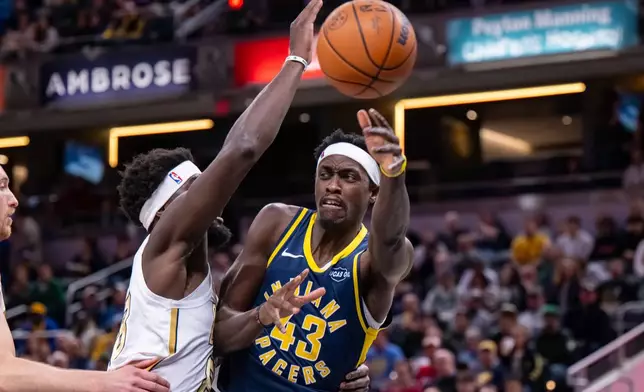 Indiana Pacers forward Pascal Siakam (43) makes a pass while being defended by Boston Celtics center Neemias Queta during the first half of an NBA basketball game in Indianapolis, Monday, Jan. 12, 2026. (AP Photo/Doug McSchooler)