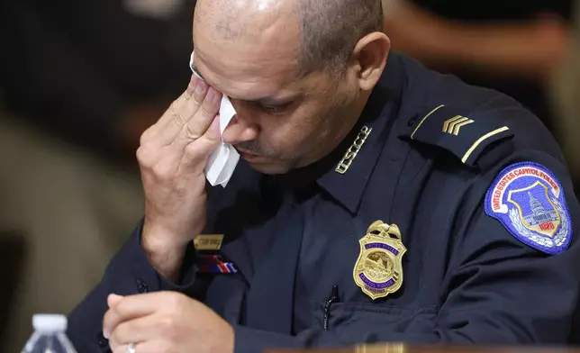 FILE - U.S. Capitol Police Sgt. Aquilino Gonell wipes his eye as he watches a video being displayed during a House select committee hearing on the Jan. 6 attack on Capitol Hill in Washington, July 27, 2021. (Jim Lo Scalzo/Pool via AP, File)