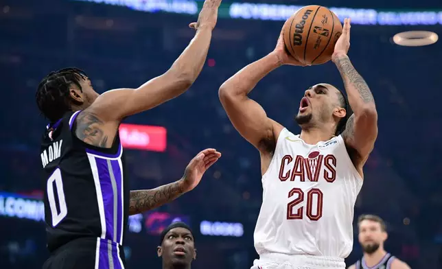 Cleveland Cavaliers guard Jaylon Tyson (20) goes to the basket against Sacramento Kings guard Malik Monk (0) in the first half of an NBA basketball game, Friday, Jan. 23, 2026, in Cleveland. (AP Photo/David Dermer)