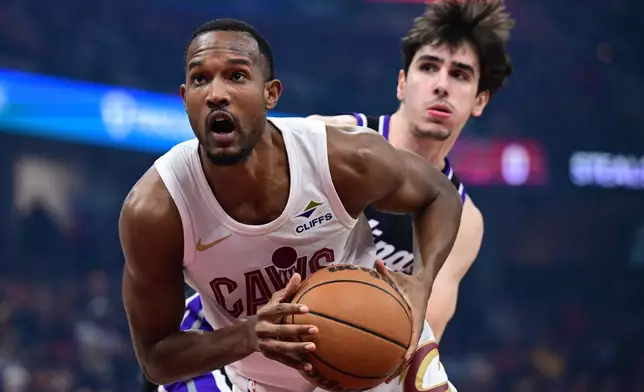 Cleveland Cavaliers center Evan Mobley, left, goes to the basket against Sacramento Kings center Maxime Raynaud in the first half of an NBA basketball game, Friday, Jan. 23, 2026, in Cleveland. (AP Photo/David Dermer)
