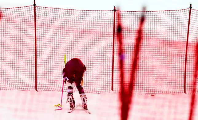 United States' Lindsey Vonn holds her left knee after crashing, during an alpine ski, women’s World Cup downhill, in Crans Montana, Switzerland, Friday, Jan. 30, 2026. (Jean-Christophe Bott/Keystone via AP)