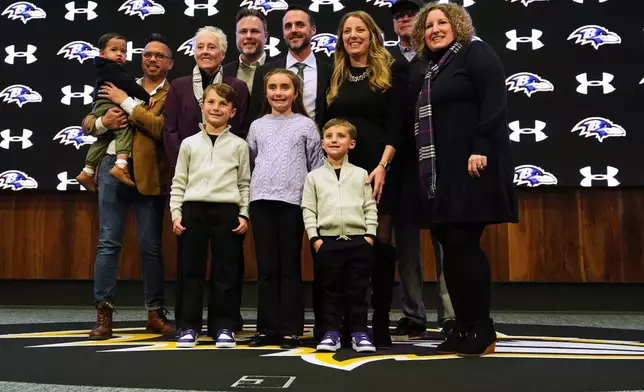 Baltimore Ravens head coach Jesse Minter poses for a photo with his family after an introductory press conference at the Under Armour Performance Center in Owings Mills, Md., Thursday, Jan. 29, 2026. (AP Photo/Stephanie Scarbrough)