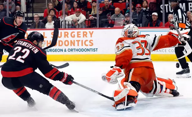 Carolina Hurricanes' Logan Stankoven (22) redirects a pass from Taylor Hall (71) past Anaheim Ducks goaltender Ville Husso (33) during the second period of an NHL hockey game in Raleigh, N.C., Thursday, Jan. 8, 2026. (AP Photo/Karl DeBlaker)