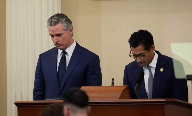 California Gov. Gavin Newsom, left, takes part in a moment of silence for the victim of a fatal shooting involving federal law enforcement agents in Minnesota, alongside California Assembly Speaker Robert Rivas, right, before his State of the State address Thursday, Jan. 8, 2026, in Sacramento, Calif. (AP Photo/Godofredo A. Vásquez)