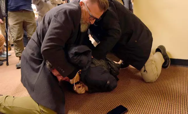 A man is tackled to the ground after spraying an unknown substance on U.S. Rep. Ilhan Omar, D-Minn., during a town hall on Tuesday, Jan. 27, 2026, in Minneapolis. (Richard Tsong-Taatarii/Star Tribune via AP)