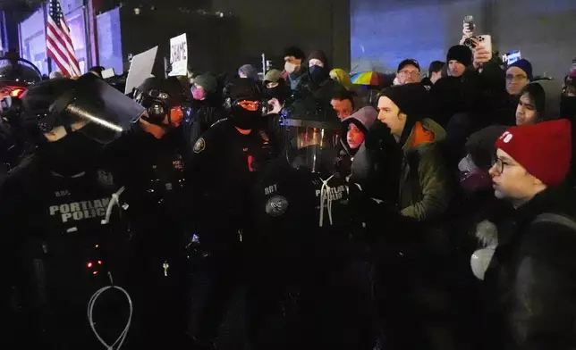 Protesters stand off against law enforcement outside the U.S. Immigration and Customs Enforcement facility in Portland, Ore., Thursday, Jan. 8, 2026. (AP Photo/Jenny Kane)