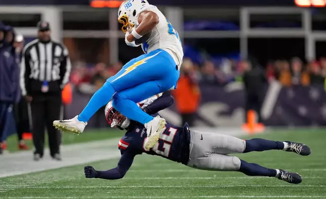 New England Patriots cornerback Charles Woods (22) tackles Los Angeles Chargers tight end Oronde Gadsden (86) in the second half of an NFL wild-card playoff football game in Foxborough, Mass., Sunday, Jan. 11, 2026. (AP Photo/Charles Krupa)