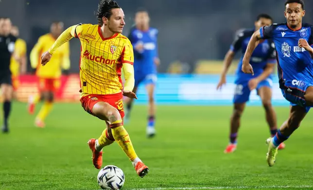 Lens' Florian Thauvin, left, in action during the French League One soccer match between Lens and Auxerre in Lens, France, Saturday, Jan. 17, 2026. (AP Photo/Jean-Francois Badias)