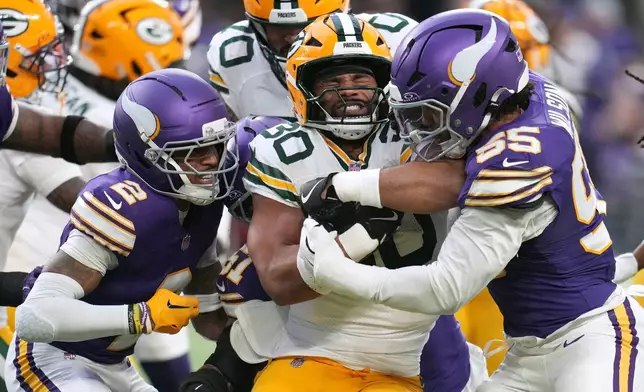 Green Bay Packers running back Chris Brooks (30) is tackled by Minnesota Vikings cornerback Isaiah Rodgers (2) and linebacker Eric Wilson (55) during the first half of an NFL football game, Sunday, Jan. 4, 2026, in Minneapolis. (AP Photo/Ross D. Franklin)