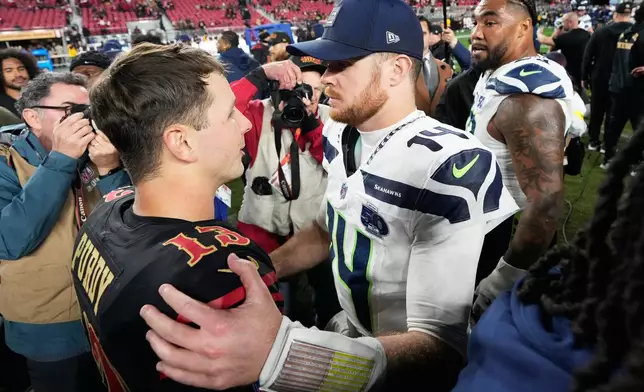 San Francisco 49ers quarterback Brock Purdy, left, talks with Seattle Seahawks quarterback Sam Darnold after an NFL football game in Santa Clara, Calif., Saturday, Jan. 3, 2026. (AP Photo/Godofredo A. Vásquez)