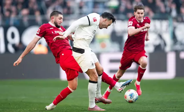 Stuttgart's Jeff Chabot, left, and Mönchengladbach's Haris Tabakovic in action during the Bundesliga soccer match between Borussia Mönchengladbach and VfB Stuttgart in Mönchengladbach, Germany, Sunday Jan. 25, 2026. (Marius Becker/dpa via AP)