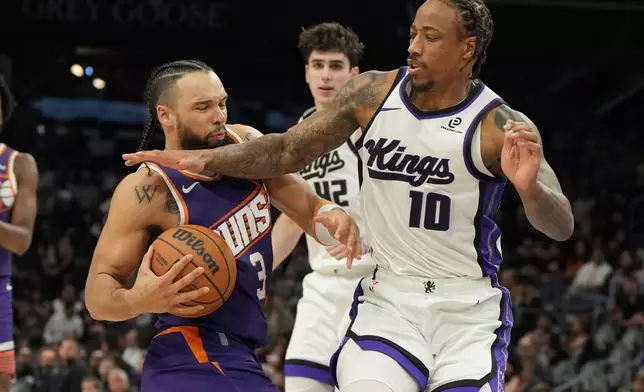 Sacramento Kings guard Demar Derozan (10) fouls Phoenix Suns forward Dillon Brooks (3) during the second half of an NBA basketball game, Friday, Jan. 2, 2026, in Phoenix. (AP Photo/Rick Scuteri)