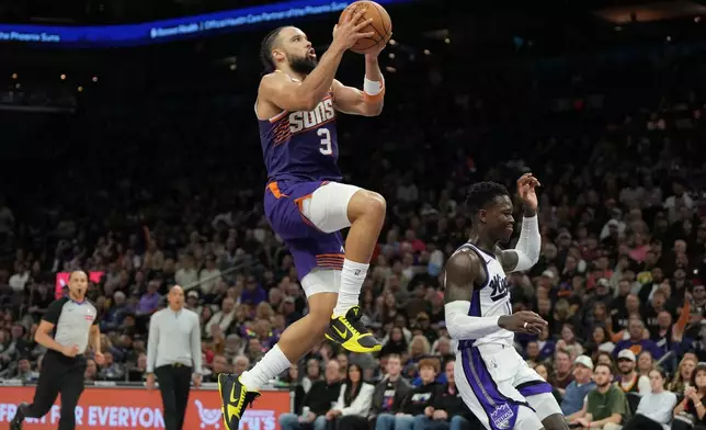 Phoenix Suns forward Dillon Brooks (3) goes up to shoot over Sacramento Kings guard Dennis Schroder, right, during the second half of an NBA basketball game, Friday, Jan. 2, 2026, in Phoenix. (AP Photo/Rick Scuteri)