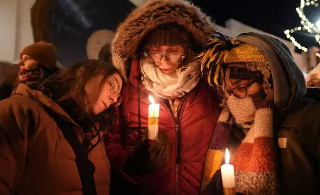 People attend a vigil where Alex Pretti was shot and killed by federal immigration enforcement in Minneapolis, on Wednesday, Jan. 28, 2026. (AP Photo/Adam Gray)