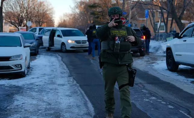 A federal officer approaches observers and journalists on Wednesday, Jan. 28, 2026, in Minneapolis. (AP Photo/Julia Demaree Nikhinson)