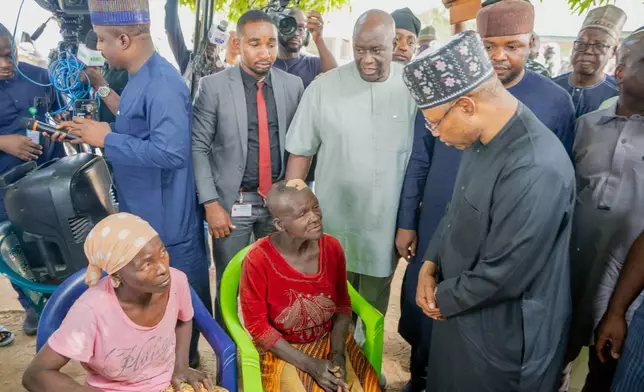 In this photo released by the Kaduna State government, Governor. Uba Sani, right, visits people that were attacked by gunmen and abducted many in Kurmin Wali, northwest Nigeria, Wednesday, Jan. 21, 2026. (Kaduna State Government via AP)