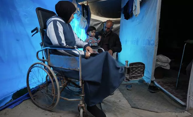 Islam Saleh, who was injured in her left leg in an Israeli strike on a school shelter in Jabalia in 2024, sits in a wheelchair inside her family's tent in Zawaida, Gaza Strip, Tuesday, Jan. 27, 2026, as she awaits permission to travel outside Gaza for treatment. (AP Photo/Abdel Kareem Hana)