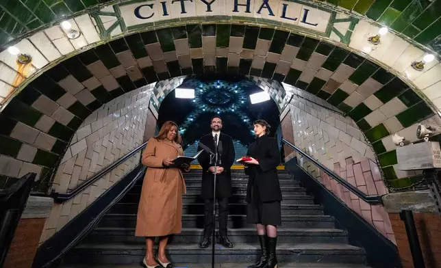 New York Attorney General Letitia James, left, administers the oath of office to mayor-elect Zohran Mamdani, center, as his wife Rama Duwaji looks on, Thursday, Jan. 1, 2026, in New York. (AP Photo/Yuki Iwamura)