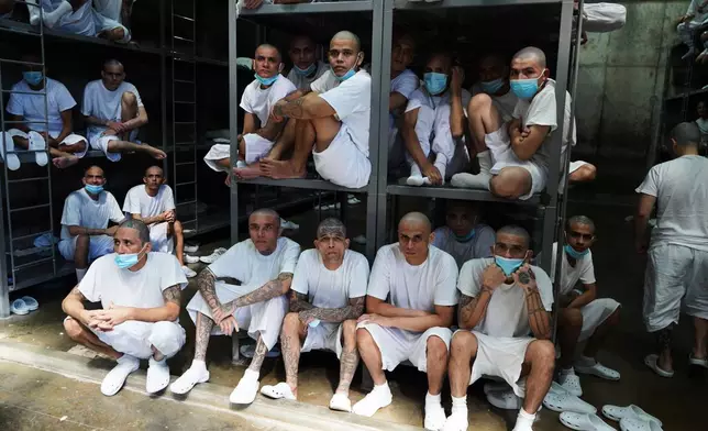Prisoners sit inside a cell at the mega the prison known as Detention Center Against Terrorism (CECOT) in Tecololuca, El Salvador, Friday, Jan. 30, 2026, during a tour for Chile's President-elect Jose Antonio Kast. (AP Photo/Salvador Melendez)