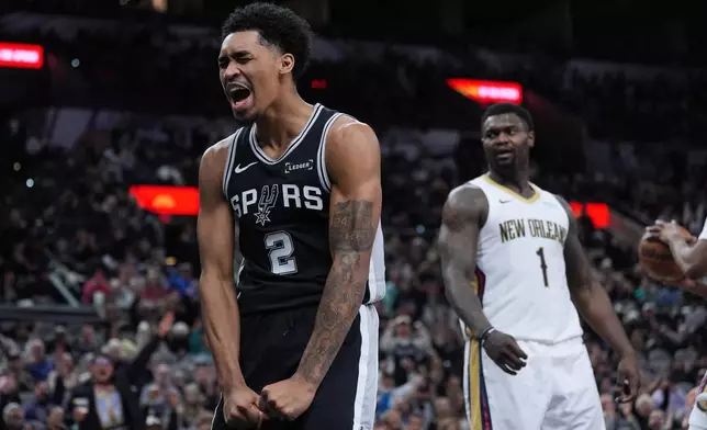 San Antonio Spurs guard Dylan Harper (2) reacts after he was fouled while scoring against New Orleans Pelicans forward Zion Williamson (1) during the second half of an NBA basketball game in San Antonio, Sunday, Jan. 25, 2026. (AP Photo/Eric Gay)