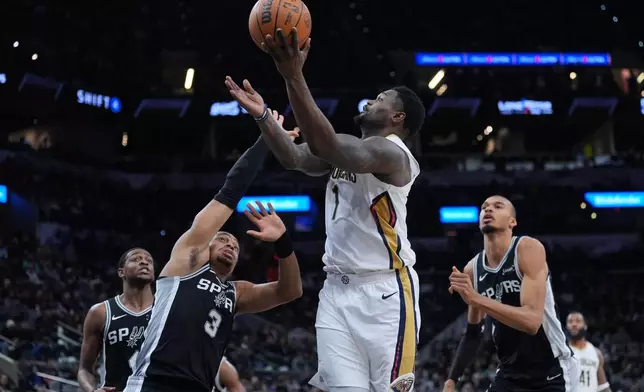 New Orleans Pelicans forward Zion Williamson (1) drives to the basket over San Antonio Spurs forward Keldon Johnson (3) during the first half of an NBA basketball game in San Antonio, Sunday, Jan. 25, 2026. (AP Photo/Eric Gay)