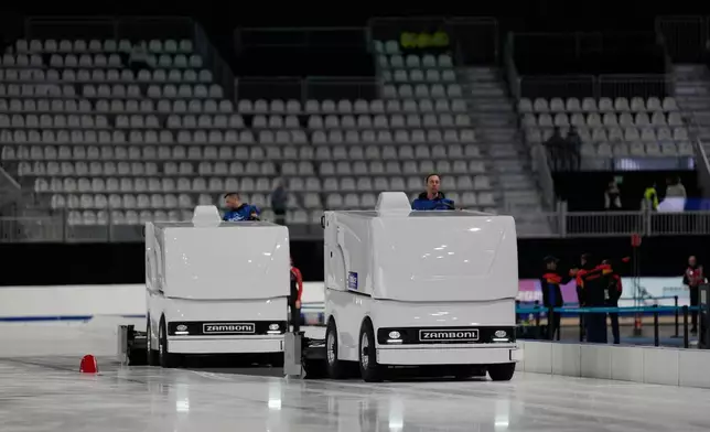 Workers clean the ice surface during a peed skating Junior World Cup and Olympic test event, in Rho, near Milan, Italy, Saturday, Nov. 29, 2025. (AP Photo/Luca Bruno)