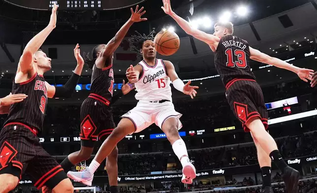 LA Clippers guard TyTy Washington Jr (15) passes the ball against Chicago Bulls center Nikola Vucevic, left, guard Ayo Dosunmu, second from left, and guard Kevin Huerter during the second half of an NBA basketball game in Chicago, Tuesday, Jan. 20, 2026. (AP Photo/Nam Y. Huh)