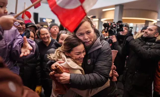 Greenland Minister for Foreign Affairs and Research Vivian Motzfeldt, center right, hugs a woman after arrival at the airport in Nuuk, Greenland, on Tuesday, Jan. 20, 2026. (AP Photo/Evgeniy Maloletka)