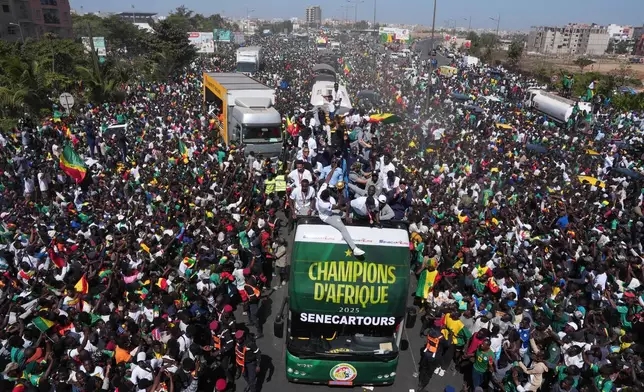 The Senegalese soccer team rides through thousands of cheering fans celebrating their victory in the Africa Cup of Nations soccer tournament, in Dakar, Senegal, Tuesday, Jan. 20, 2026. (AP Photo/Misper Apawu)