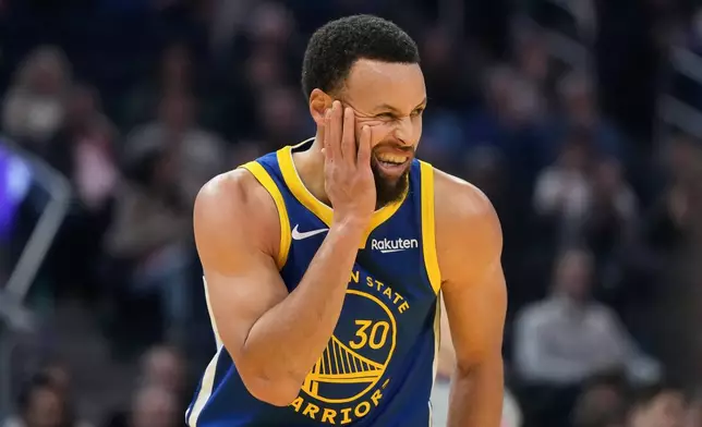 Golden State Warriors guard Stephen Curry (30) reacts after contact from a Milwaukee Bucks player during the first half of an NBA basketball game in San Francisco, Wednesday, Jan. 7, 2026. (AP Photo/Jeff Chiu)