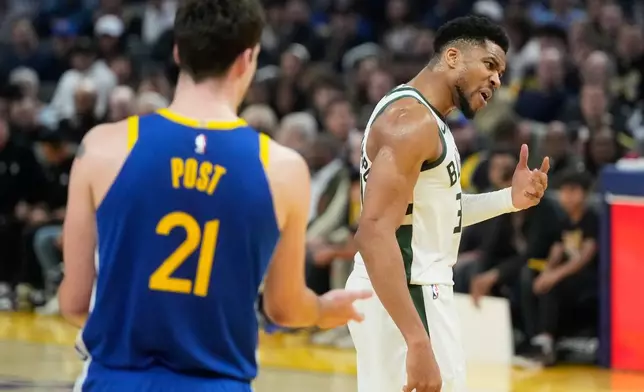 Milwaukee Bucks forward Giannis Antetokounmpo, right, gestures toward an official near Golden State Warriors center Quinten Post (21) during the first half of an NBA basketball game in San Francisco, Wednesday, Jan. 7, 2026. (AP Photo/Jeff Chiu)