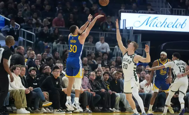 Golden State Warriors guard Stephen Curry (30) shoots against a 3-point basket against Milwaukee Bucks guard AJ Green (20) during the first half of an NBA basketball game in San Francisco, Wednesday, Jan. 7, 2026. (AP Photo/Jeff Chiu)