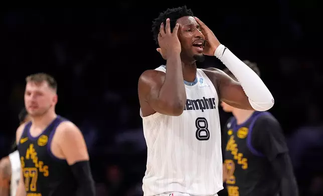 Memphis Grizzlies forward Jaren Jackson Jr., right, reacts after being called for a foul on Los Angeles Lakers guard Luka Doncic, left, during the first half of an NBA basketball game Friday, Jan. 2, 2026, in Los Angeles. (AP Photo/Mark J. Terrill)