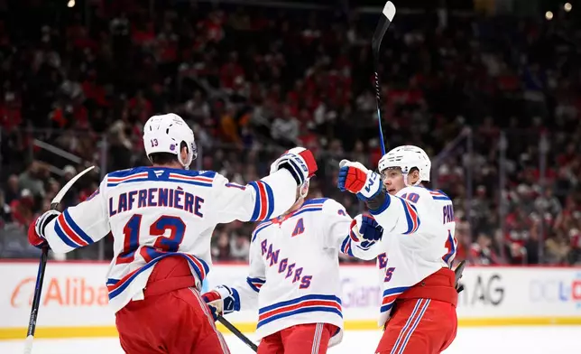 CORRECTS TO GOAL MADE BY VINCENT TROCHEK - New York Rangers left wing Artemi Panarin (10), left wing Alexis Lafrenière (13) and Adam Fox, center, celebrate Vincent Trochek's goal during the first period of an NHL hockey game Washington Capitals, Wednesday, Dec. 31, 2025, in Washington. (AP Photo/Nick Wass)