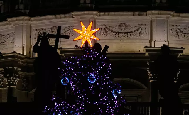 The lit Christmas tree is backdropped by the St. Peter's Basilica at the Vatican, Thursday, Jan. 8, 2026. (AP Photo/Gregorio Borgia)