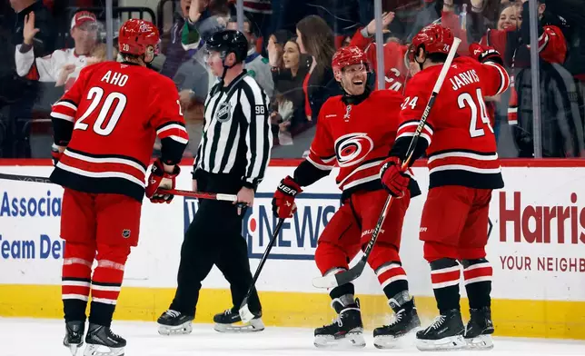 Carolina Hurricanes' Nikolaj Ehlers celebrates his hat trick goal against the Florida Panthers with teammates Seth Jarvis (24) and Sebastian Aho during the third period of an NHL hockey game in Raleigh, N.C., Friday, Jan. 16, 2026. (AP Photo/Karl DeBlaker)
