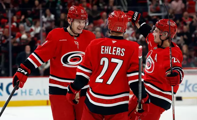 Carolina Hurricanes' Alexander Nikishin celebrates his goal with teammate Sebastian Aho, right, and Nikolaj Ehlers (27) during the second period of an NHL hockey game against the Florida Panthers in Raleigh, N.C., Friday, Jan. 16, 2026. (AP Photo/Karl DeBlaker)