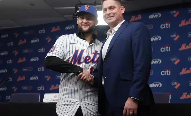 Bo Bichette, left, shakes hands with New York Mets manager Carlos Mendoza during his introductory press conference, Wednesday, Jan. 21, 2026, in New York. (AP Photo/Heather Khalifa)