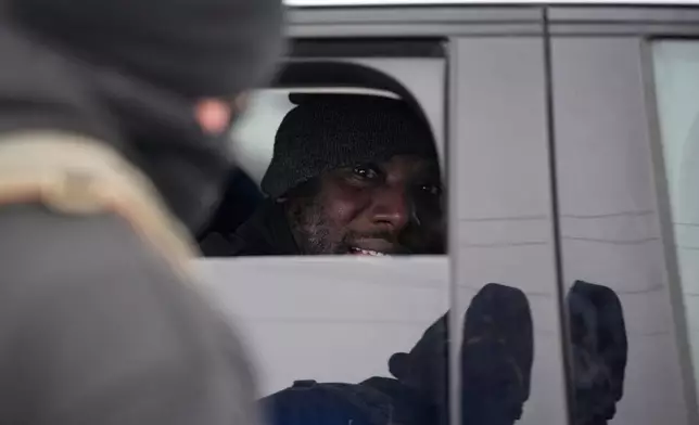 A man looks out of a car window after being detained by Immigration and Customs Enforcement (ICE) agents during a traffic stop, Sunday, Jan. 11, 2026, in Robbinsdale, Minn. (AP Photo/John Locher)