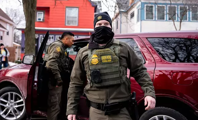 Federal agents look on after detaining a person during a patrol in Minneapolis, Minn., Sunday, Jan. 11, 2026. (Christopher Katsarov/The Canadian Press via AP)