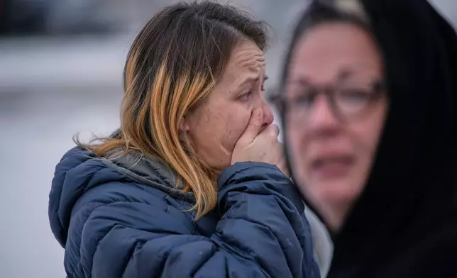 Bystanders react after a man was detained by Immigration and Customs Enforcement (ICE) agents during a traffic stop, Sunday, Jan. 11, 2026, in Robbinsdale, Minn. (AP Photo/John Locher)